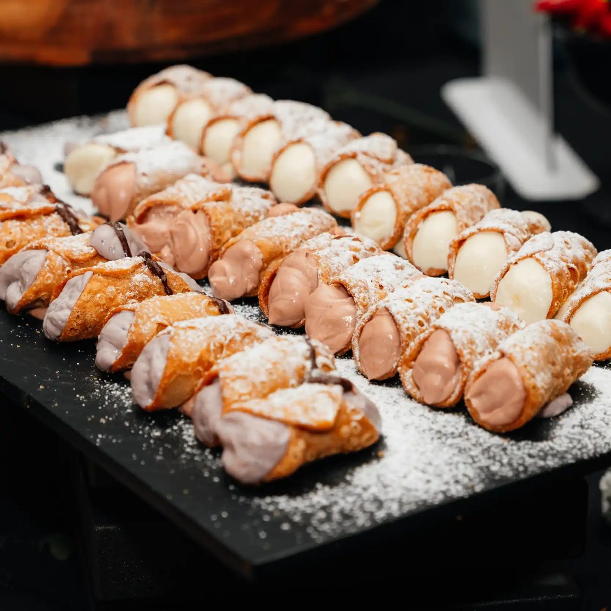 Trays of cannoli dusted with icing sugar
