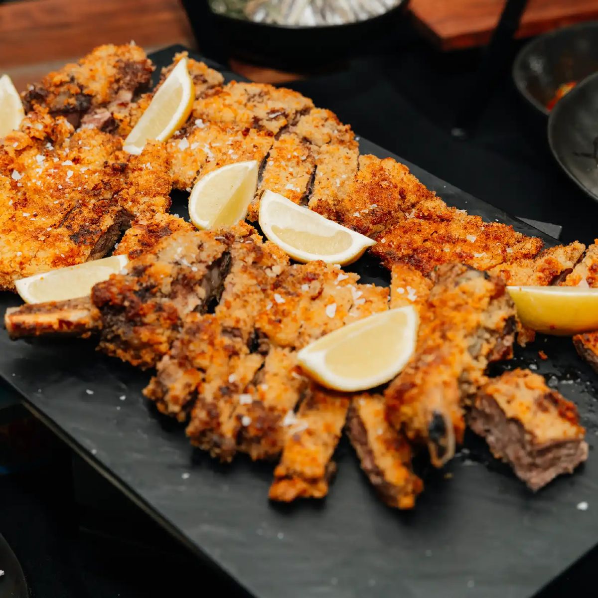 Crumbed cotoletta with lemon wedges