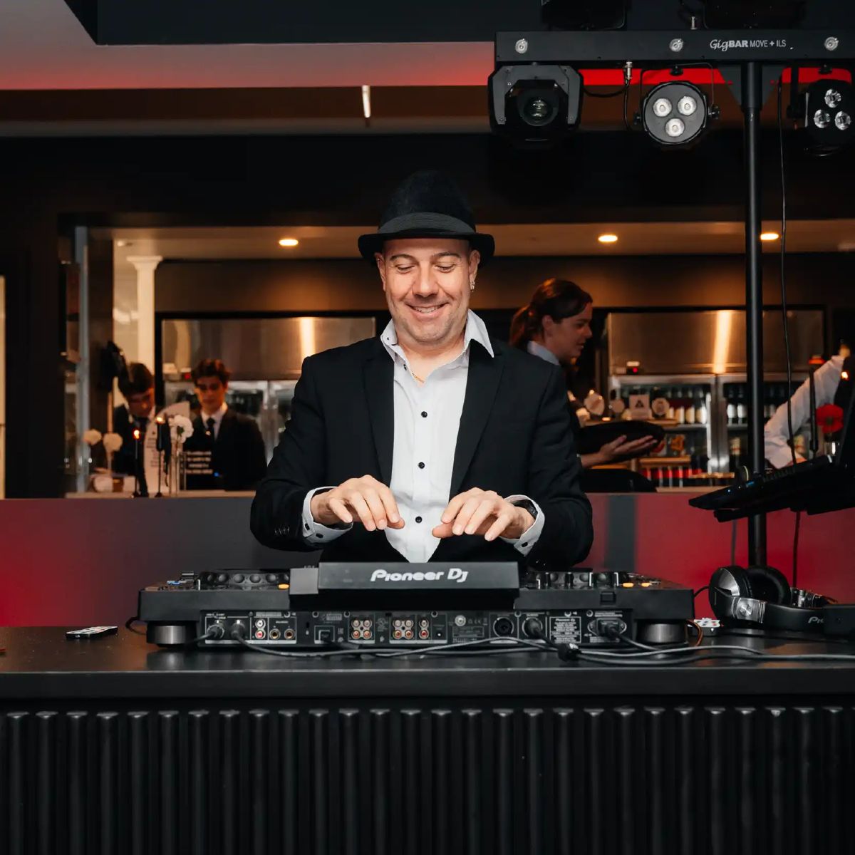 A DJ in a fedora at the decks