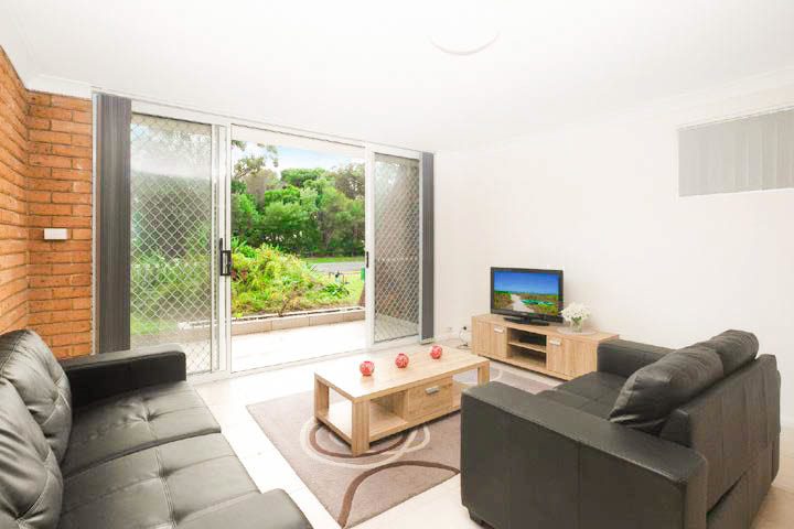 Open-plan living room with leather sofas opening to the patio